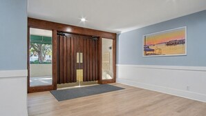 Un hall d’hôtel avec une porte en bois, un tableau encadré et un plancher en bois.
