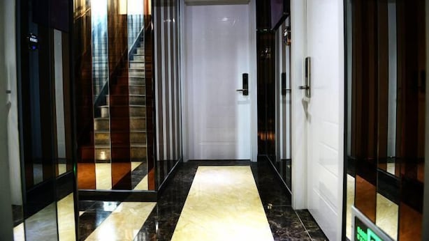 A modern hotel lobby with a marble floor, a staircase, and a closed door. - Yuedi Hotel (Shanghai)