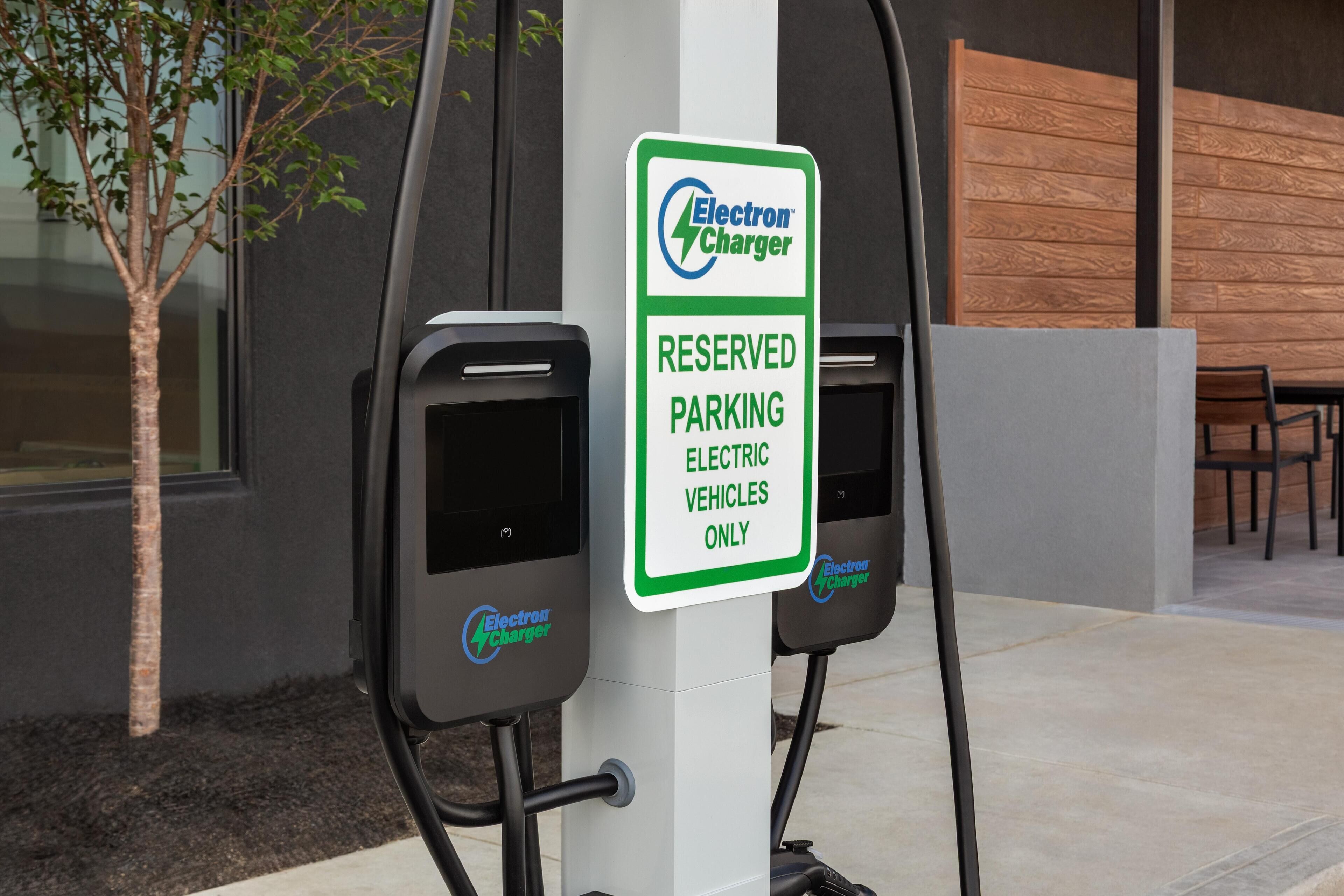 An electric vehicle charging station with a sign indicating it is reserved for electric vehicles only.