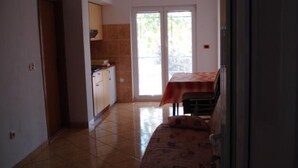 A kitchen with a dining area, a sofa, and a sliding glass door leading to an outdoor space. - Apartments Radacic - Two Bedroom Apartment With Terrace And Sea View (A1) (Sevid)