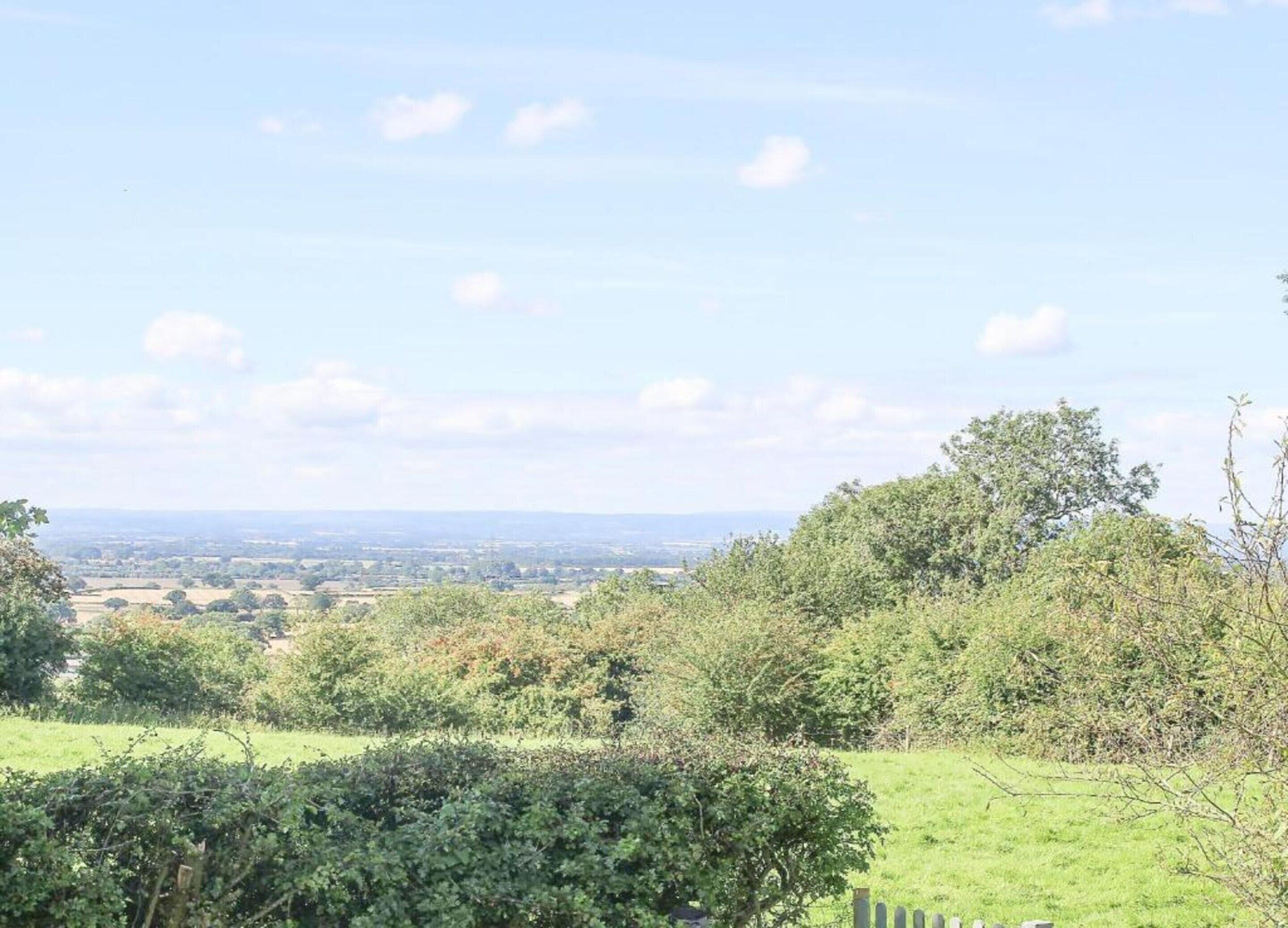 A rural landscape with a view of distant fields and a clear sky.
