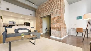 Uma sala de estar moderna com sofá, mesa de centro e lareira de tijolos.