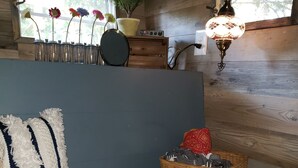 Una habitación acogedora con un banco, una cesta de mimbre y una lámpara colgante.