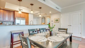 A modern kitchen with wooden cabinets, stainless steel appliances, and pendant lighting.