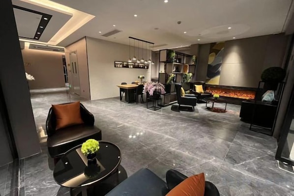 A modern interior with a seating area, a dining space, and a fireplace.