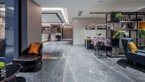 A modern interior with a seating area, a bookshelf with plants, and a dining space. - Homeinn Selected Hotel (Shanghai Xinzhuang Subway Station North Square) (Shanghai)