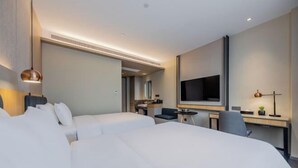 A hotel room with two beds, a desk, a chair, a television, and a mirror. - Homeinn Selected Hotel (Shanghai Xinzhuang Subway Station North Square) (Shanghai)