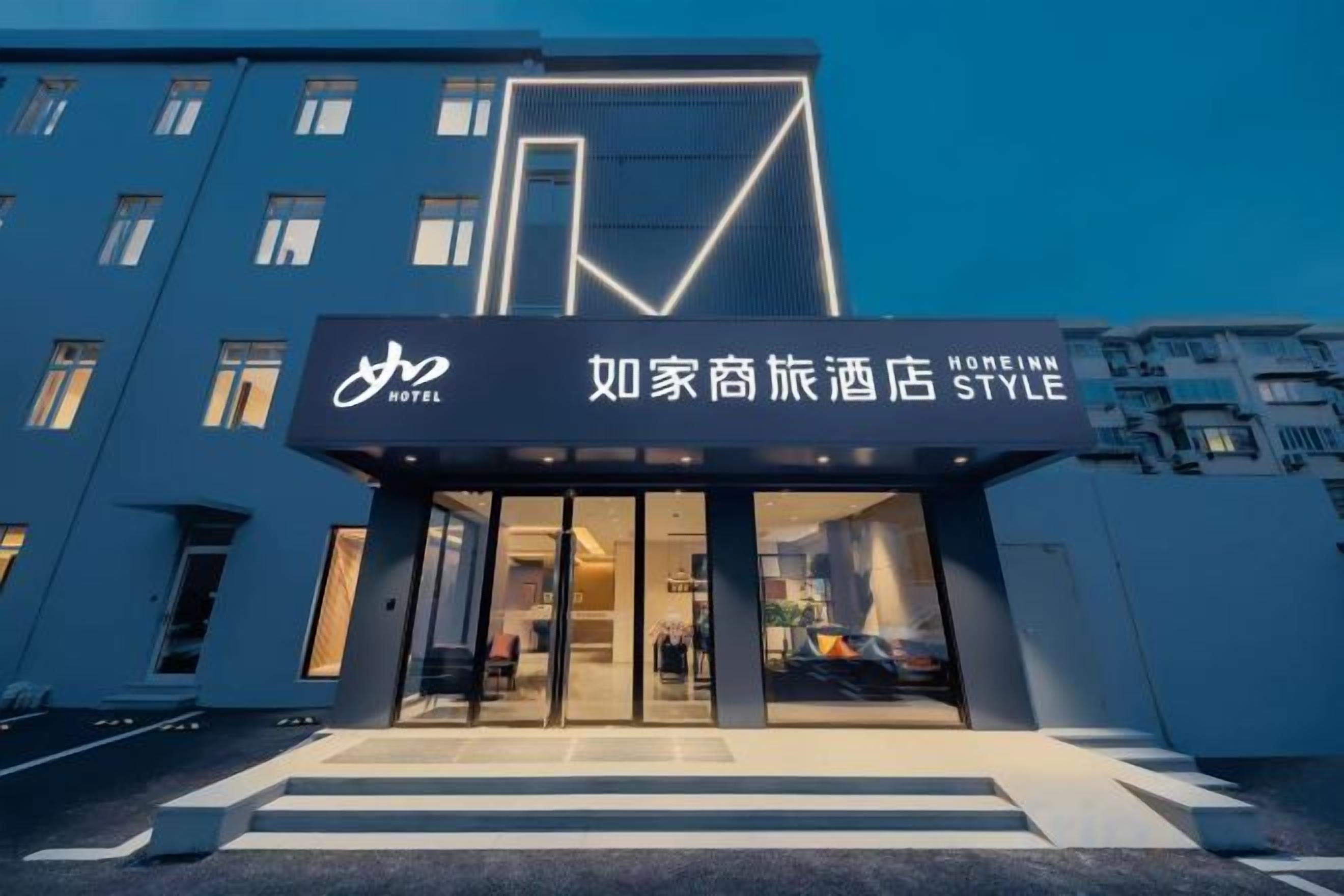 A hotel entrance with a modern design, featuring a prominent logo and signage.
