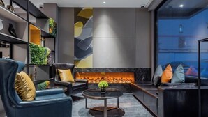 A modern living room with a fireplace, comfortable seating, and a decorative wall. - Homeinn Selected Hotel (Shanghai Xinzhuang Subway Station North Square) (Shanghai)