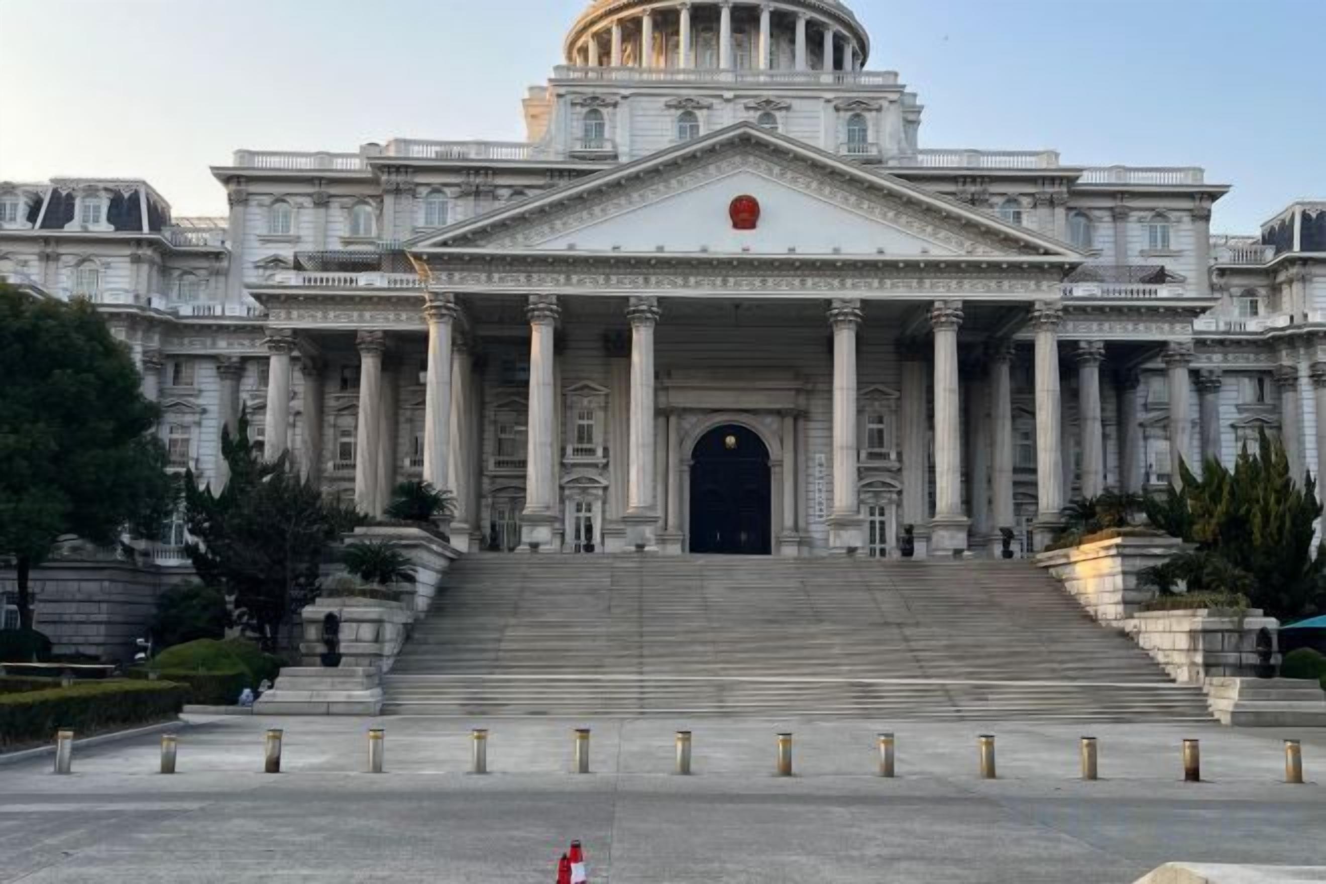 A large, classical building with a central dome and multiple columns.