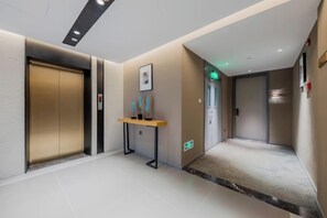 Un hall d’hôtel comprenant un comptoir d’accueil, une œuvre d’art accrochée au mur et un sol recouvert de moquette.