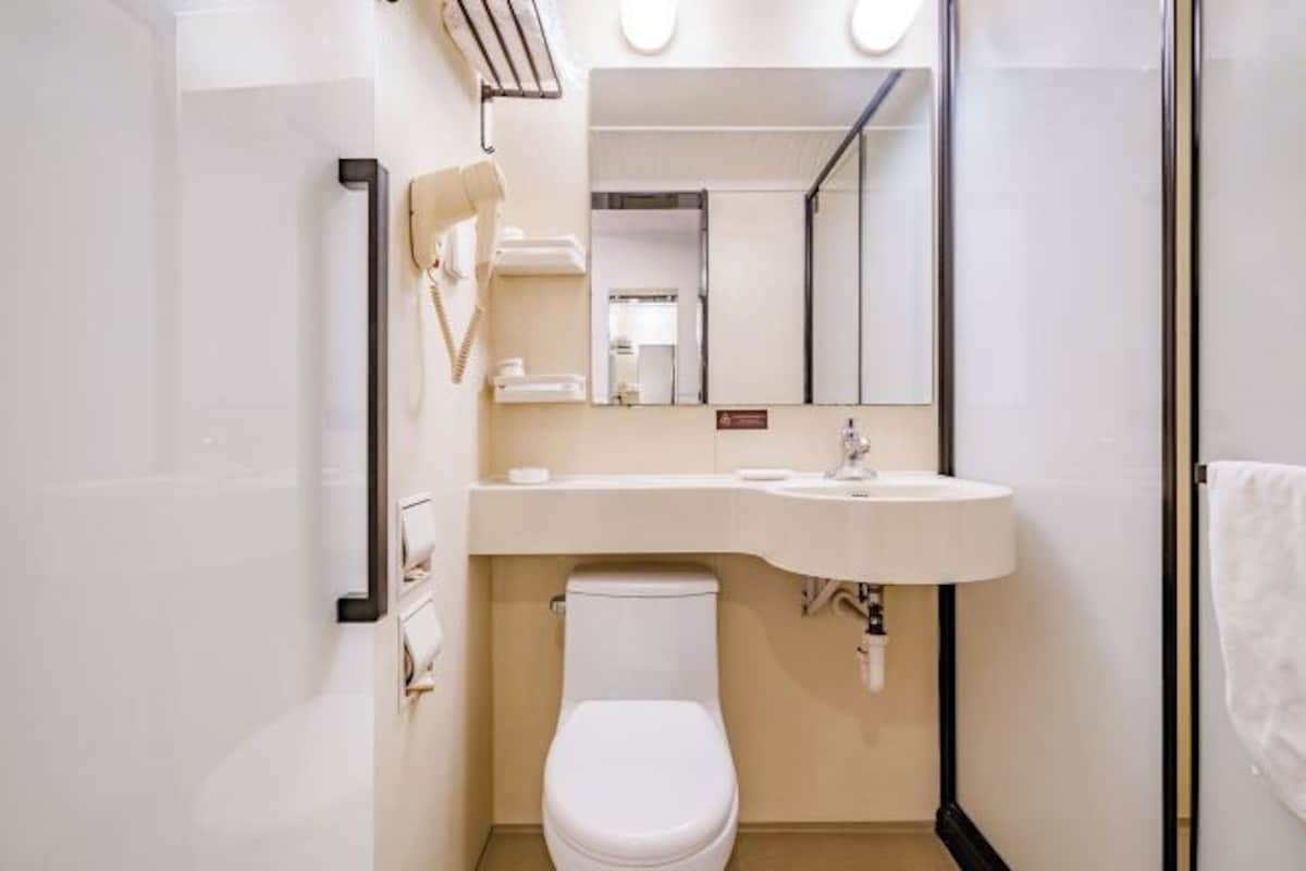 Un baño pequeño y moderno con inodoro, lavamanos y espejo.