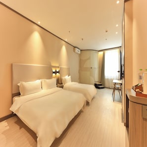 Una habitación de hotel con dos camas, un escritorio y baño.