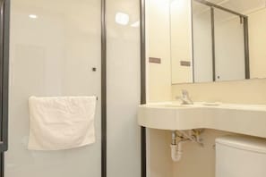A bathroom with a white sink, a mirror, and a towel hanging on the wall.