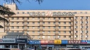 Een meerlaags gebouw met het bord "JINJIANGINN" duidelijk zichtbaar.