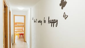 Un corridoio con un letto a castello e un cartello motivazionale con la scritta “Don't worry be happy.”