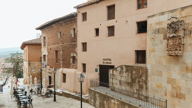 Ostello con un cartello che indica la sua posizione presso una chiesa.