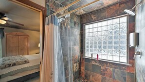 A bathroom with a shower, a window with a view, and a bed with a curtain. -  Cozy Fairway Retreat - Near Ski, Golf & Town (Red Lodge)