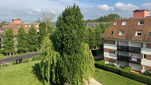 A residential building with a balcony, a clear sky, and surrounding greenery. - New cocoon between sea and countryside 4Pers Private parking (Villers-sur-Mer)