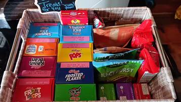 A basket filled with various breakfast cereals and snacks.