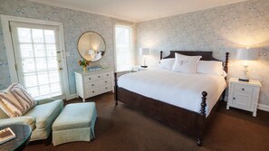 Classic design with a large four-poster bed, nightstands, and a dresser with mirror.