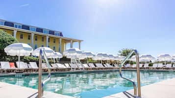 Relax by the pool surrounded by comfortable lounge chairs and umbrellas.
