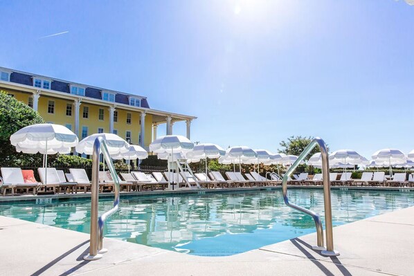 Relax by the pool surrounded by comfortable lounge chairs and shaded by umbrellas.