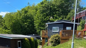 A small cabin with a wooden deck and a covered porch. - Cosy holiday chalet (Cearnarfo)