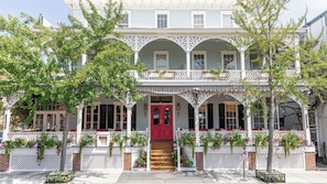 Stunning two-story building with a central red door and charming balcony.