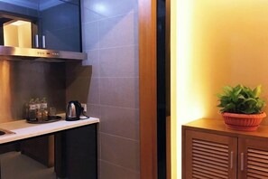 A modern kitchen with a built-in stove, a coffee maker, and a potted plant. - Qiyue Shangpin Cinema Hotel Apartment (Guanyinqiao Branch) (Chongqing)