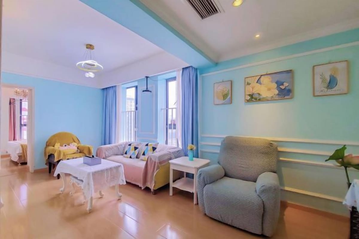Una habitación con sofá, sillón, mesa y cortinas.