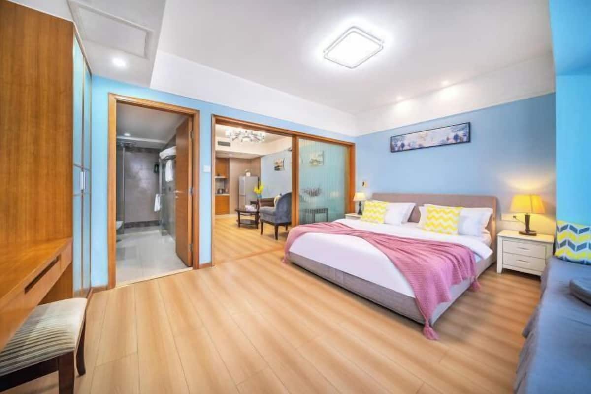 Une chambre à coucher comprenant un lit, une table de chevet et un bureau avec une chaise.