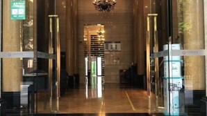 A hotel lobby with a chandelier, glass doors, and a reception desk. - Qiyue Shangpin Cinema Hotel Apartment (Guanyinqiao Branch) (Chongqing)