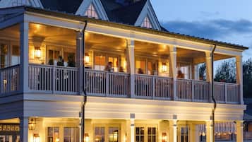 Guests can enjoy a spacious balcony with columns, outdoor seating, and a gabled roof.