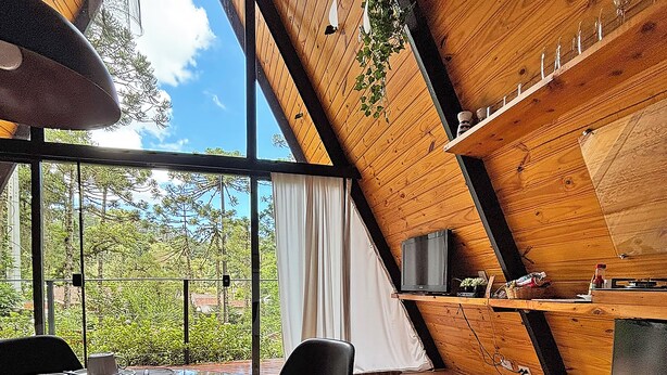 A modern interior with a dining area, large windows, and wooden beams. - Chalet Mon Amour 1 - Pure design in pure air. Hydro, fire pit, pet friendly (Jd do Embaixador Campos do Jordão)