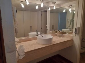 Un bagno moderno con uno specchio grande, due lavandini e un porta asciugamani.