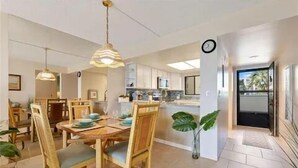 A modern kitchen with white cabinets, a built-in oven, and a large island.
