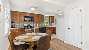 Une cuisine moderne avec des meubles en bois, un îlot central et un coin repas avec des chaises.