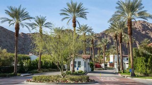 A resort entrance with palm trees, a mountain backdrop, and a clear sky. - Legacy Villas- 1 BR Suite with separate Living Room,Patio, Views,Sleeps 4-064225 (La Quinta)