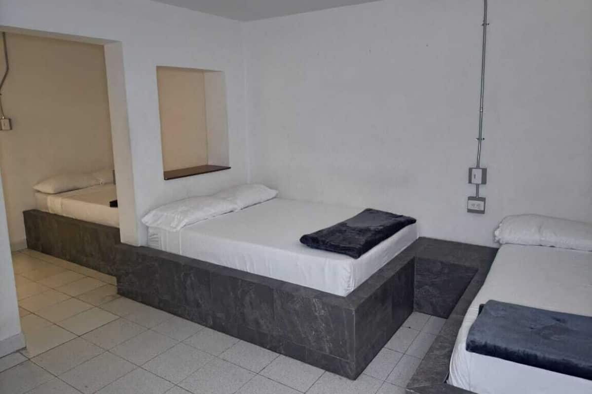 Une chambre moderne avec un lit, un petit coin salon et une douche.