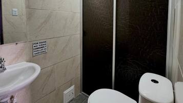 Een douche, handdoeken, zeep, toiletpapier