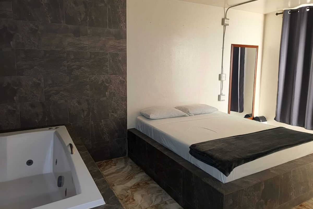 Une salle de bain moderne avec une baignoire, un espace douche et un grand miroir.