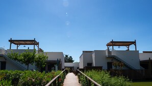 A wooden pathway leading to a building with a covered walkway on either side.