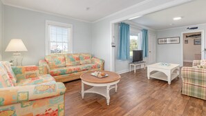A living room with a sofa, a round coffee table, and a television.