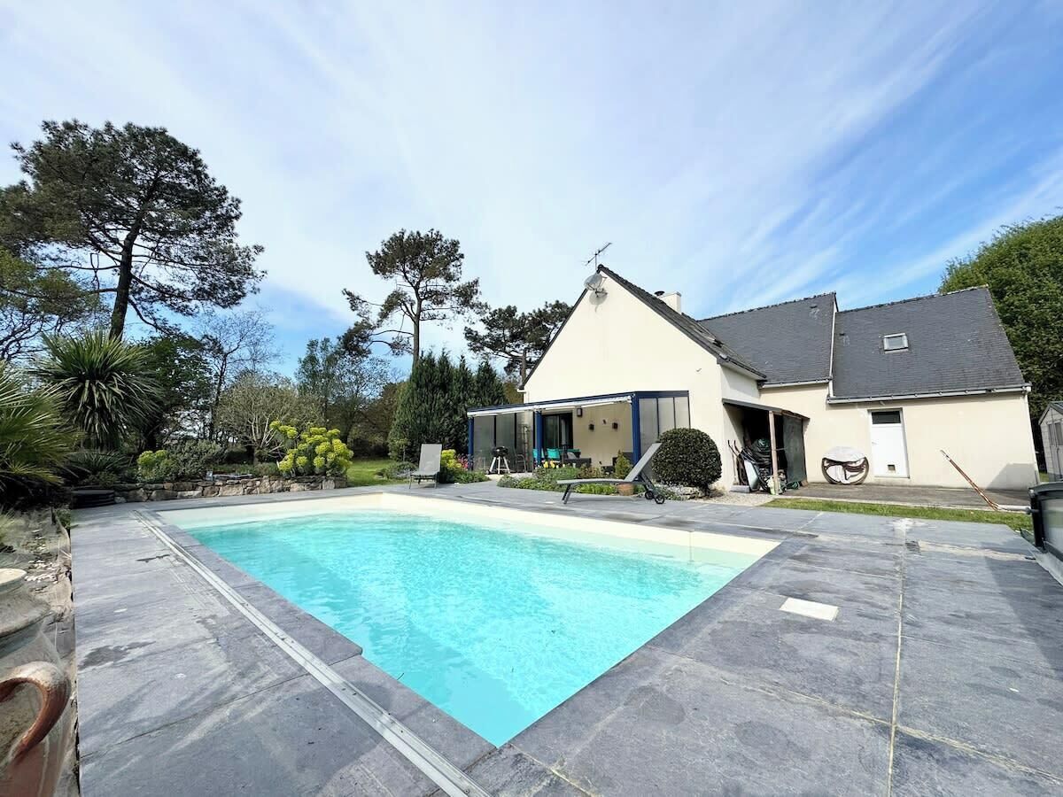 Una piscina amb una casa al fons.