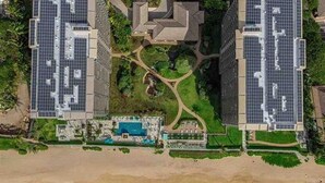 Ein Strandhotel mit Solaranlage, Pool und einem Innenhof.