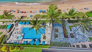 Eine Vogelperspektive eines Resorts mit Schwimmbad, Strand und Palmen.