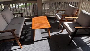 A covered outdoor seating area with a view of a lake and golf course.