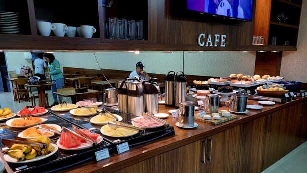 A buffet counter with various food items and hot beverages.