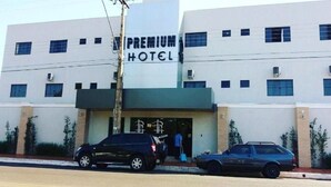 A hotel with a sign reading "PREMIUM HOTEL" and a person exiting the building.